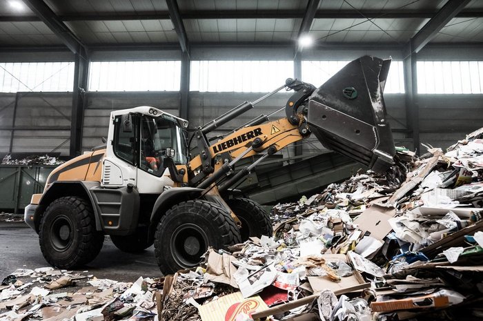 Das foto zeigt eine Recyclinghalle mit Fahrzeug