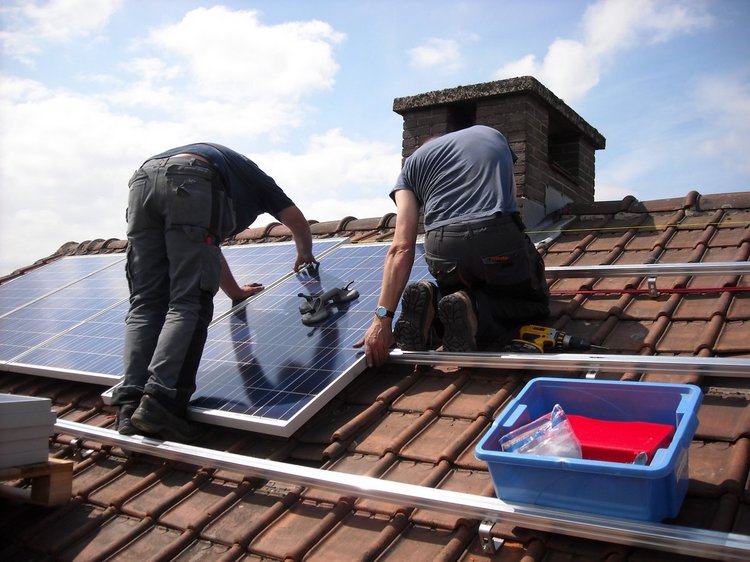 Das Foto zeigt stellvertretend für alle Berufe der Energiewirtschaft zwei Männer bei der Montage einer Solaranlage