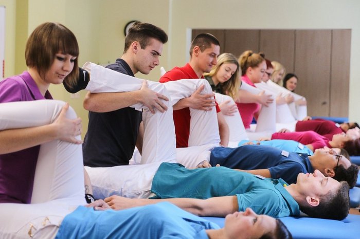 Das Foto zeigt eine Gruppe angehender Physiotherapeuten, bei einer Übung